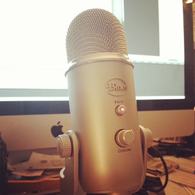Blue Yeti Microphone on a Desk with Mac behind